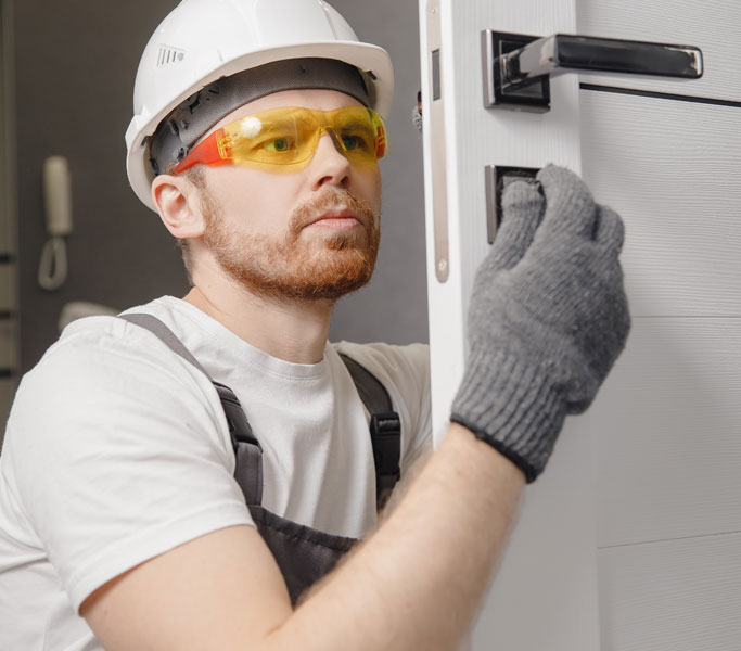 Maintenance engineer repairing a door lock